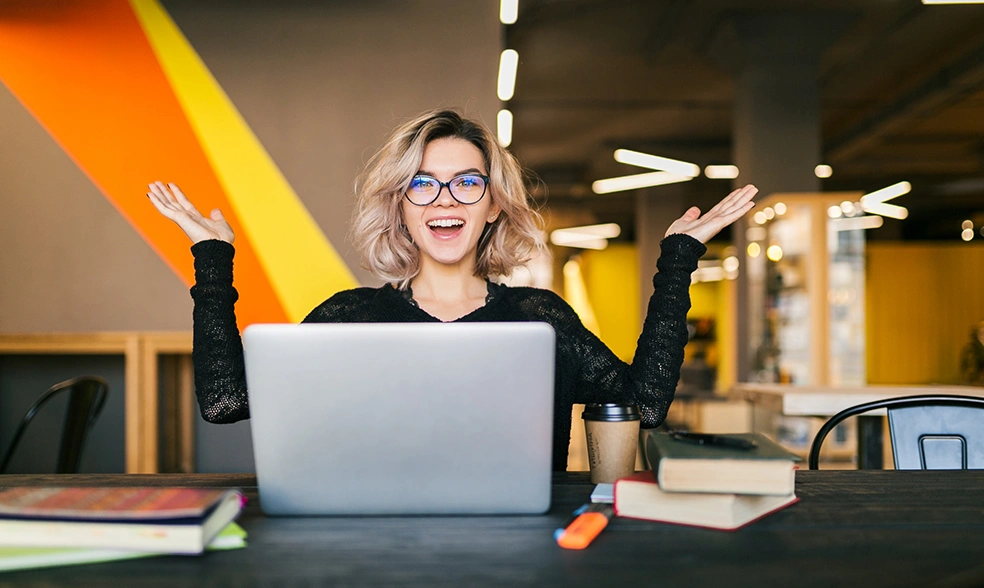 funny-happy-excited-young-pretty-woman-sitting-table-black-shirt-working-laptop-co-working-office-wearing-glasses